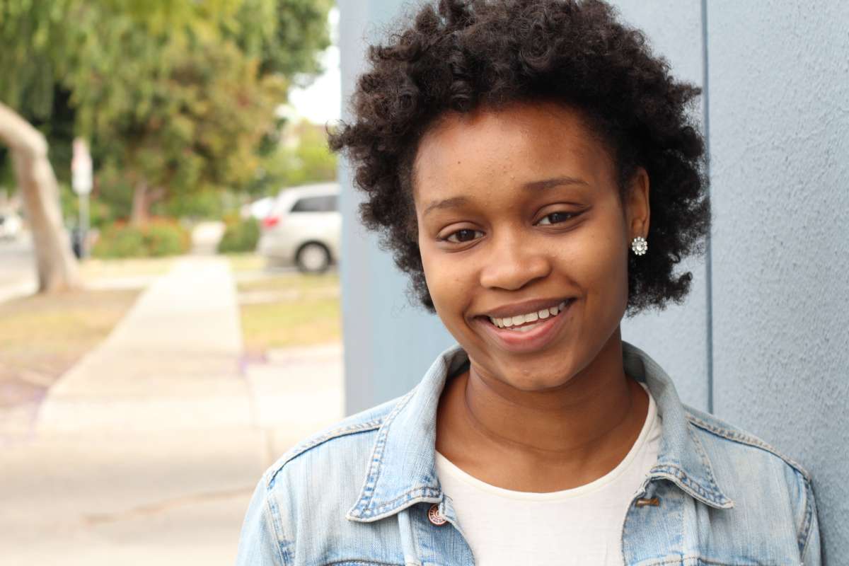 A teenage woman smiling at the camera