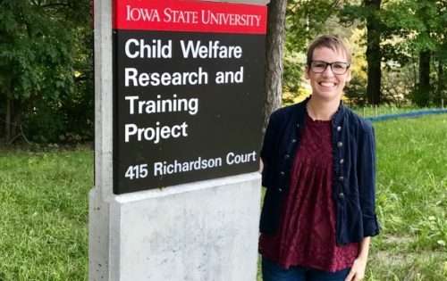 Kate Goudy is standing next to the sign outside of CWRTP's office