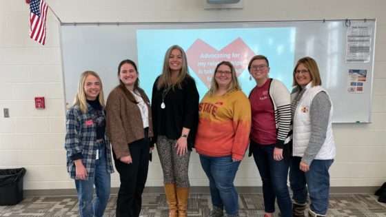 PIAL students posing in a classroom with a domestic violence advocate