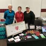 Three CWRTP staff members pose behind their booth at the 2017 Professional and Scientific Fair